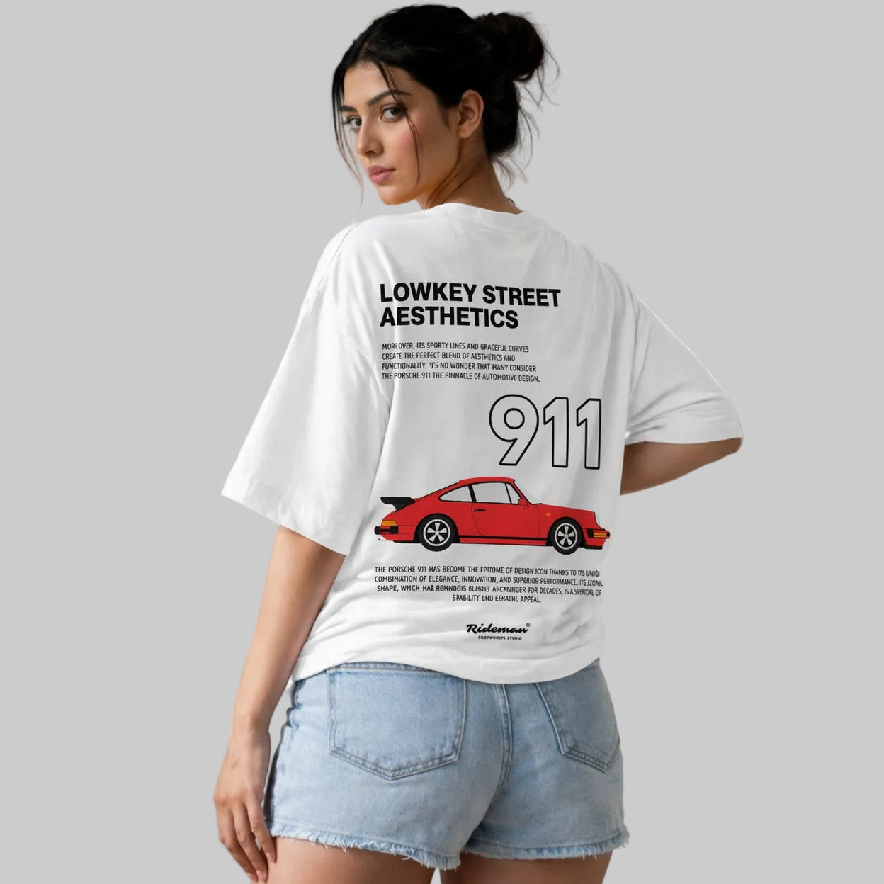 Person wearing a white t-shirt with a red car graphic and text on the back.