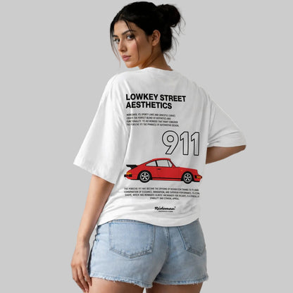 Person wearing a white t-shirt with a red car graphic and text on the back.