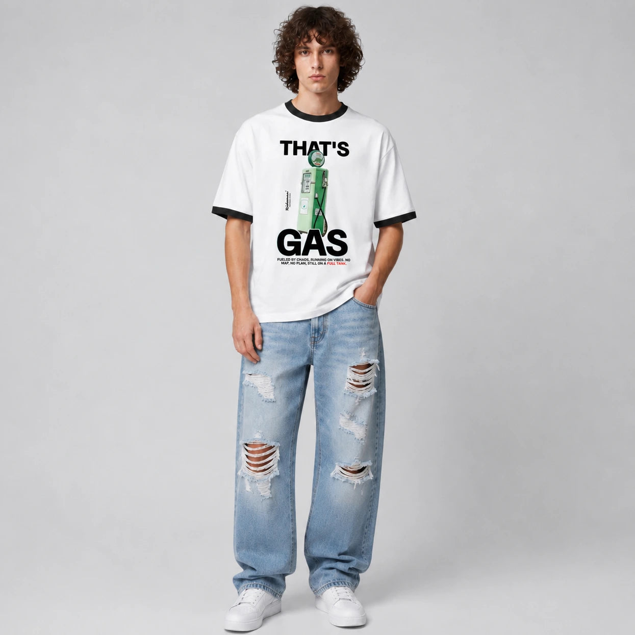 A model stands against a light gray studio background wearing a white ringer T-shirt with black trim and a green-and-black graphic print that reads 'THAT'S GAS,' paired with light blue ripped jeans and white sneakers.
