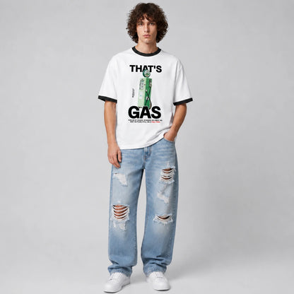 A model stands against a light gray studio background wearing a white ringer T-shirt with black trim and a green-and-black graphic print that reads 'THAT'S GAS,' paired with light blue ripped jeans and white sneakers.