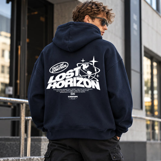 Model wearing navy blue Lost Horizon oversized hoodie, showing the white globe-and-star back graphic.
