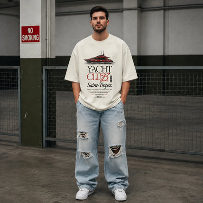 Man wearing off-white Yacht Club Saint-Tropez oversized tee with ripped denim jeans