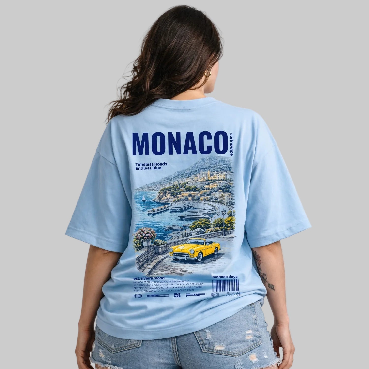 Person wearing a light blue t-shirt with Monaco design on the back