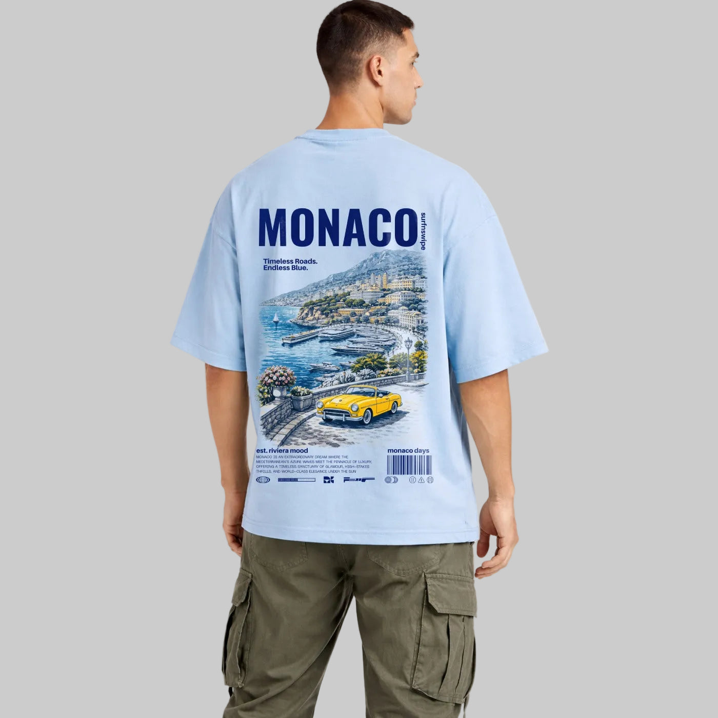 Man wearing a light blue t-shirt with Monaco graphic design on a white background