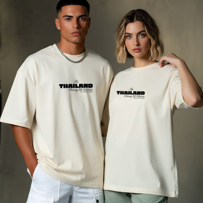 Two people wearing cream t-shirts with 'The Thailand' text on a neutral background
