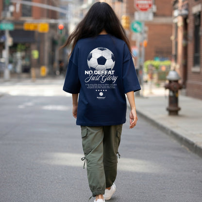 Person wearing a navy blue t-shirt with a soccer ball design and text on a city street.