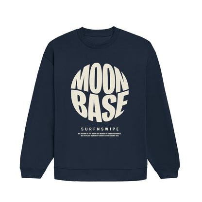 A navy blue crewneck sweatshirt with a large cream-colored graphic on the front reading 'MOON BASE' in a circular design, with 'SURFNSWIPE' printed below it, shown against a plain white background.