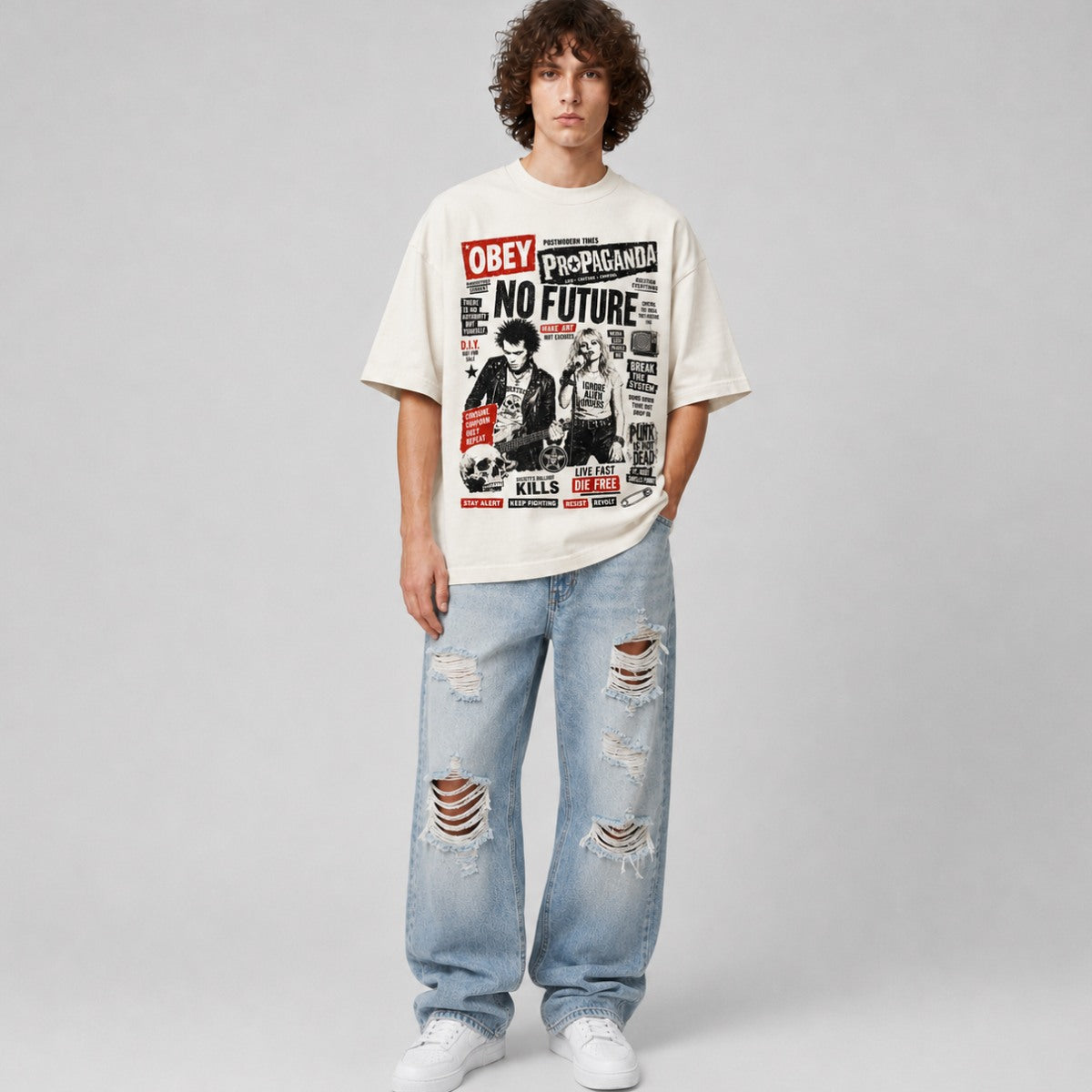 Person wearing a graphic t-shirt and ripped jeans on a plain background
