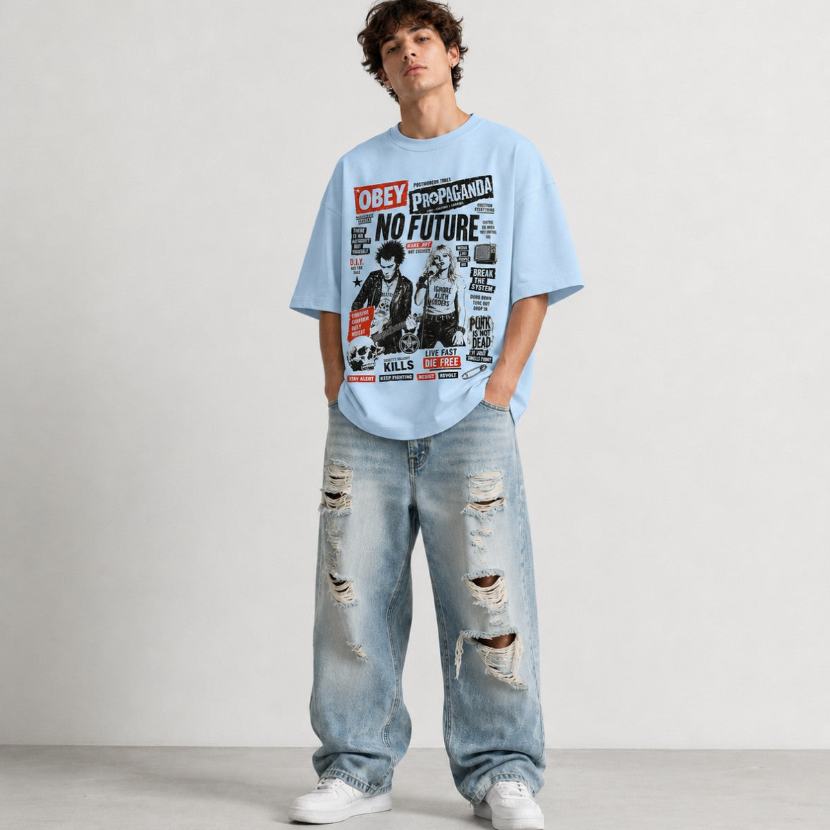 Person wearing a graphic t-shirt and ripped jeans on a plain background