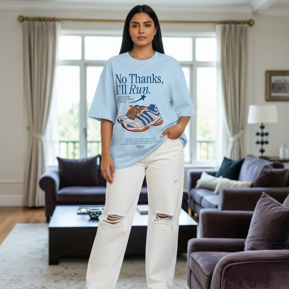 Woman wearing a light blue t-shirt with a graphic and text in a living room.