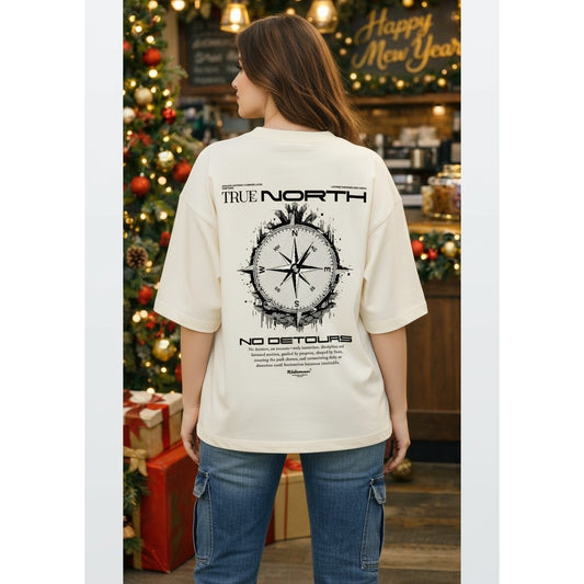 Person wearing a 'True North' t-shirt with a compass design in a festive setting.
