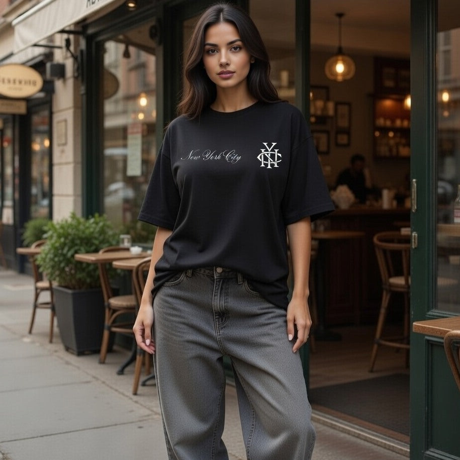 Woman wearing a black t-shirt with a logo and text, standing on a city street.