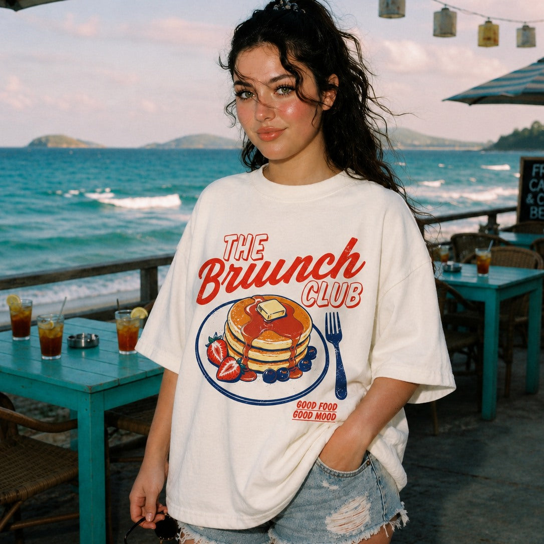 Woman wearing a 'The Brunch Club' t-shirt by the beach.