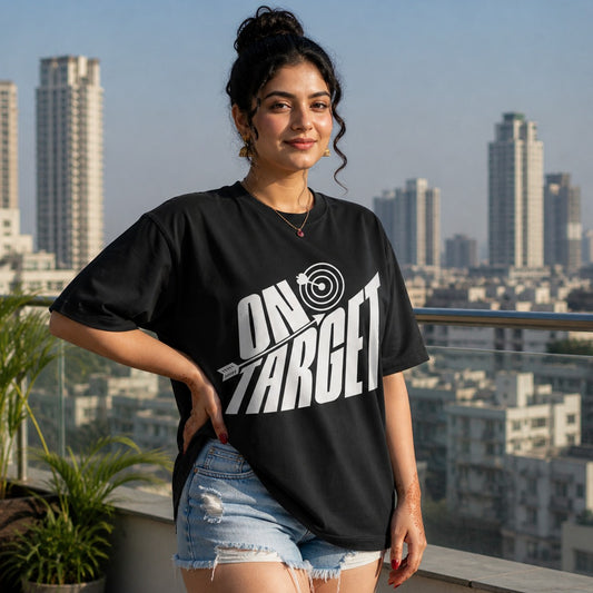 Woman wearing a black t-shirt with 'On Target' graphic on a rooftop with cityscape in the background