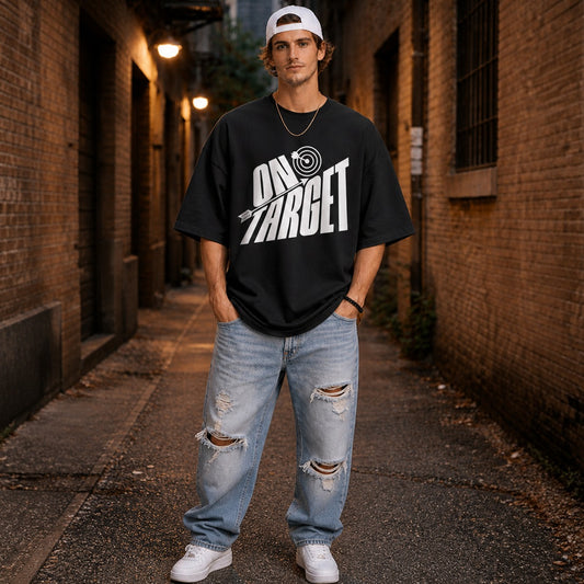 man wearing a black t-shirt with 'On Target' graphic on a rooftop with cityscape in the background