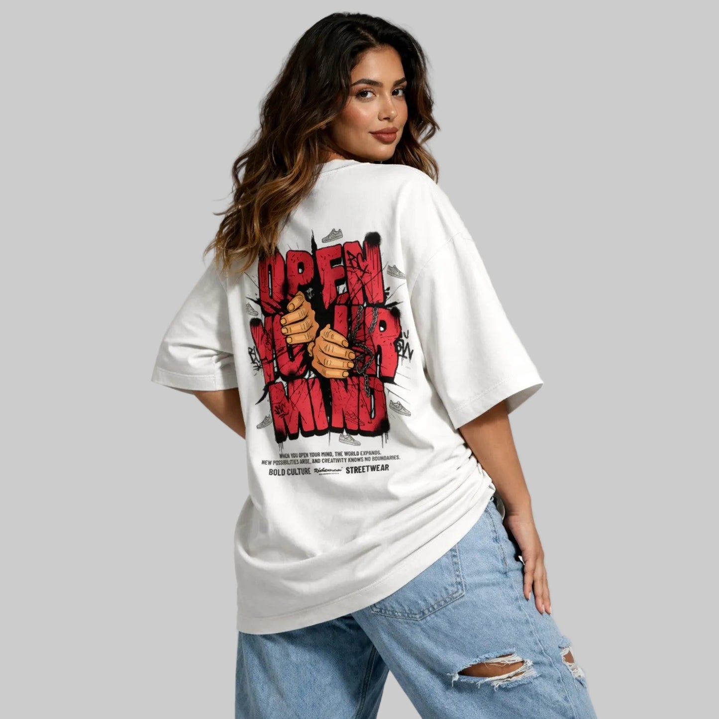 Woman wearing a white t-shirt with graphic design and text, standing against a plain background