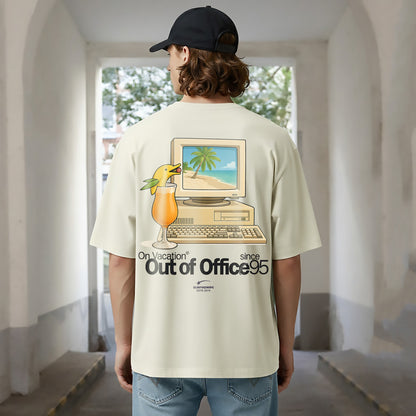 Person wearing a t-shirt with a graphic design of a computer and a drink, standing in an indoor setting.