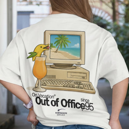 Person wearing a t-shirt with a vintage computer and beach scene design.