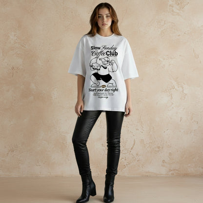 Person wearing a white t-shirt with graphic design and text on a plain background