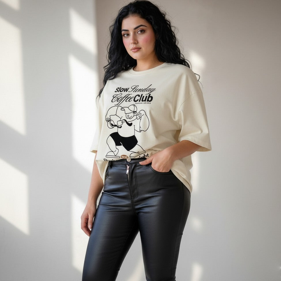 Woman wearing a white t-shirt with a graphic design and text, standing against a neutral background.