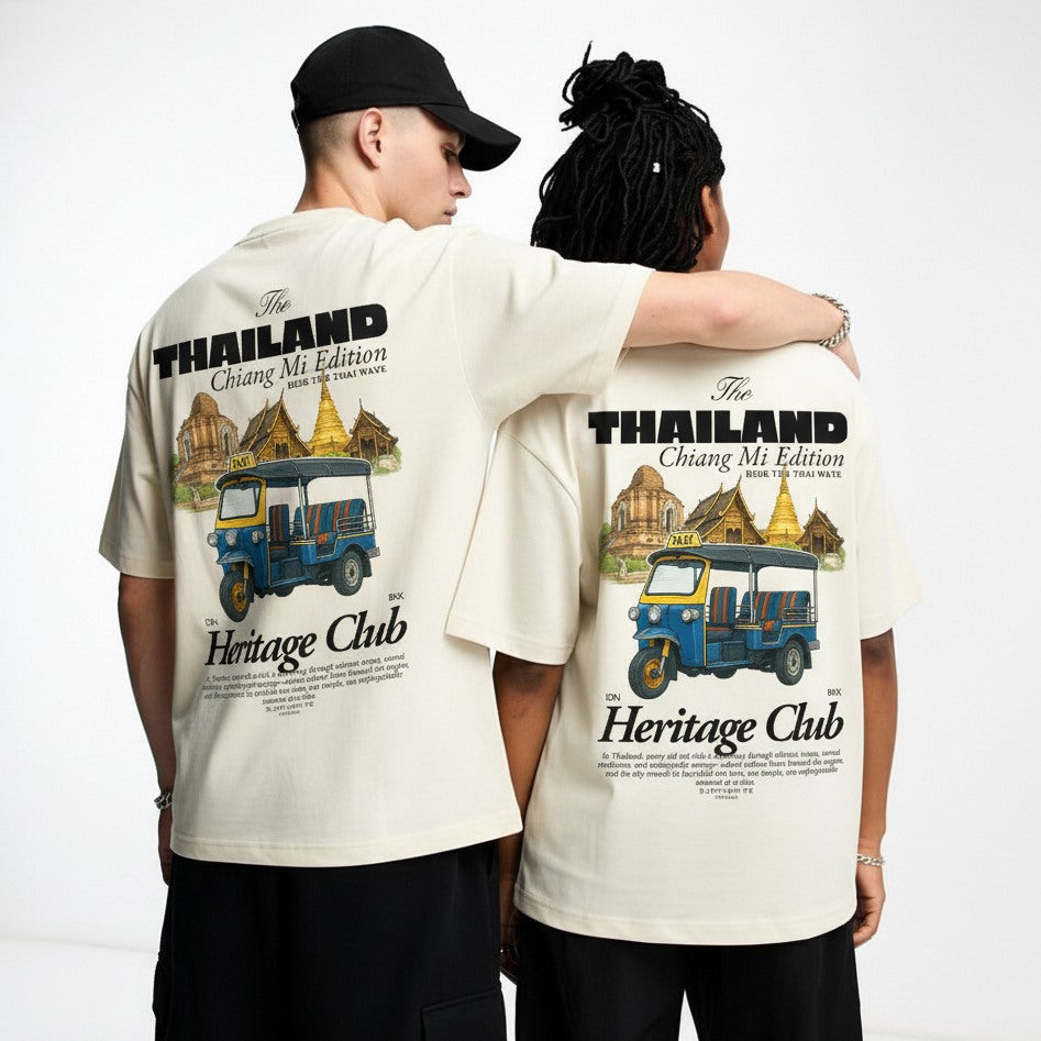 Two people wearing matching t-shirts with a tuk-tuk design and 'Heritage Club' text on a white background.