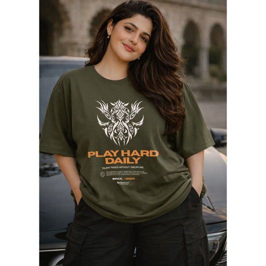 Woman wearing a green t-shirt with 'Play Hard Daily' text and design.