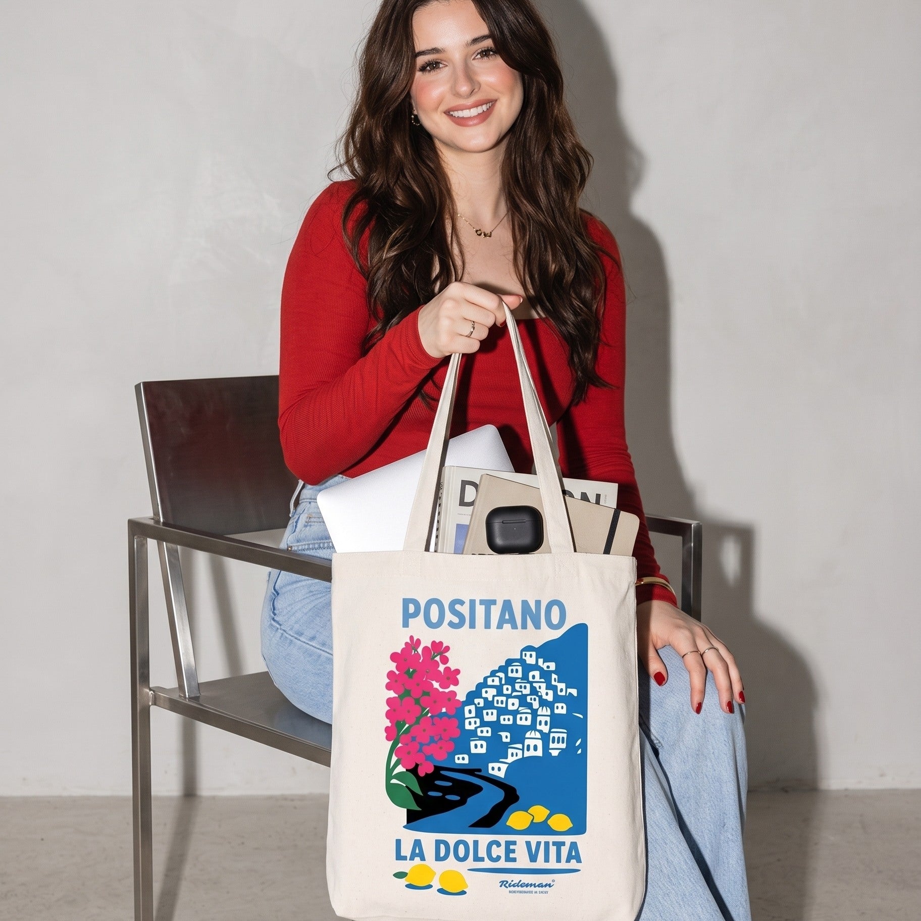 Woman holding a tote bag with 'Positano La Dolce Vita' design.