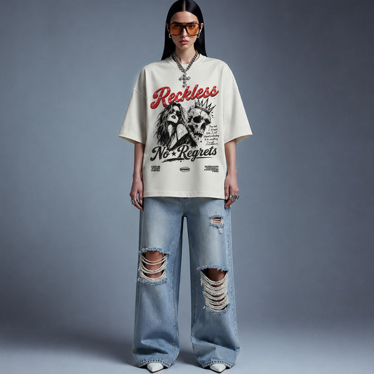 Person wearing a graphic t-shirt and ripped jeans on a gray background
