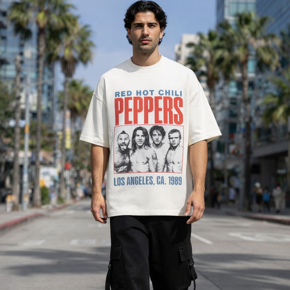 Person wearing a Red Hot Chili Peppers t-shirt on a city street with palm trees.