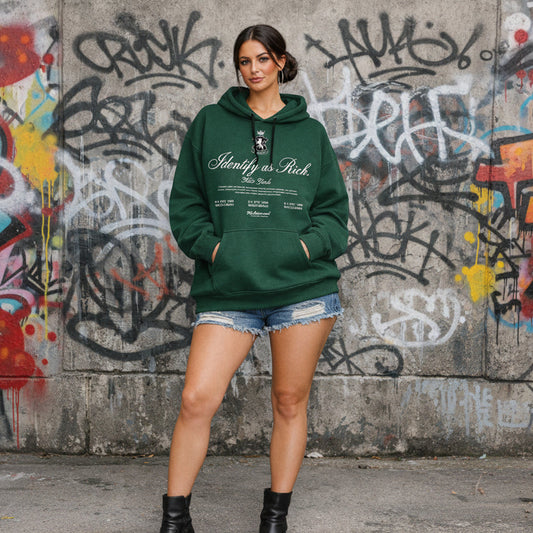 Woman wearing a green hoodie with text in front of a graffiti-covered wall