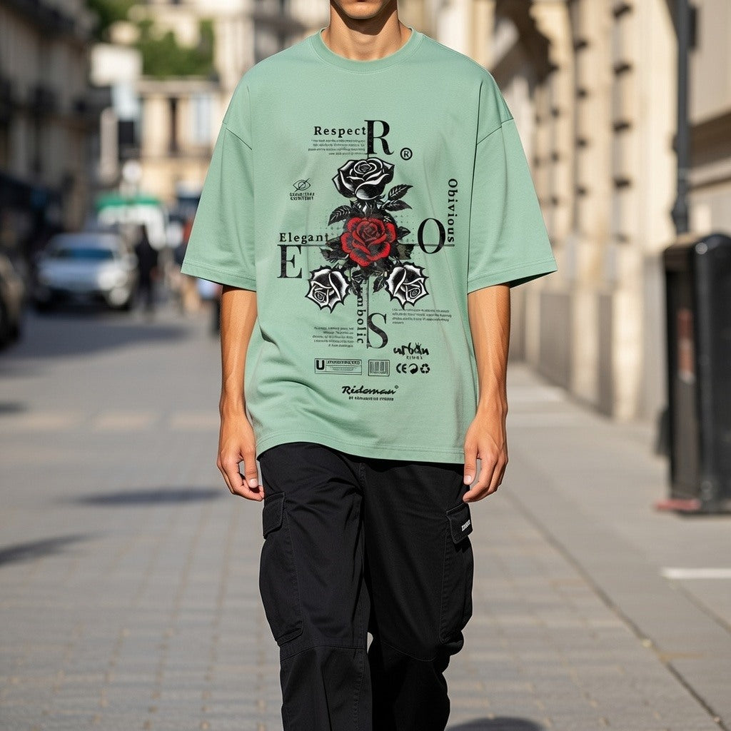 Person wearing a green t-shirt with a graphic design on a city street.