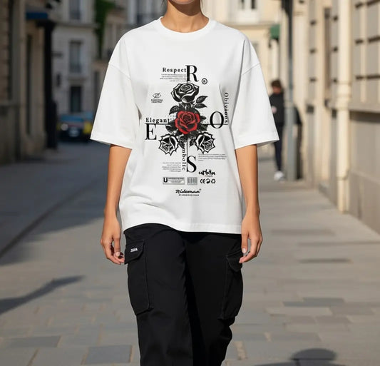 Person wearing a white t-shirt with black and red graphics on a city street.