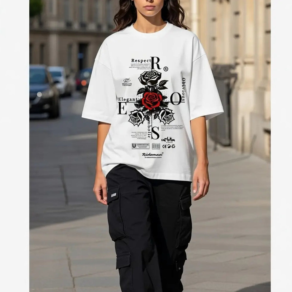 Person wearing a white t-shirt with black and red graphics on a city street.