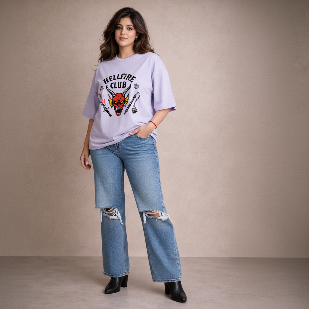 Woman wearing a 'Hellfire Club' t-shirt and ripped jeans against a plain background