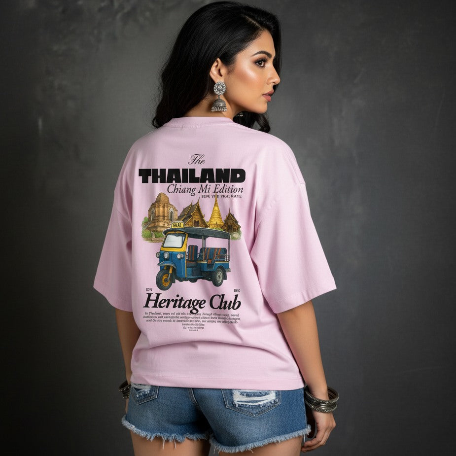 Woman wearing a pink t-shirt with Thailand-themed design on a dark background