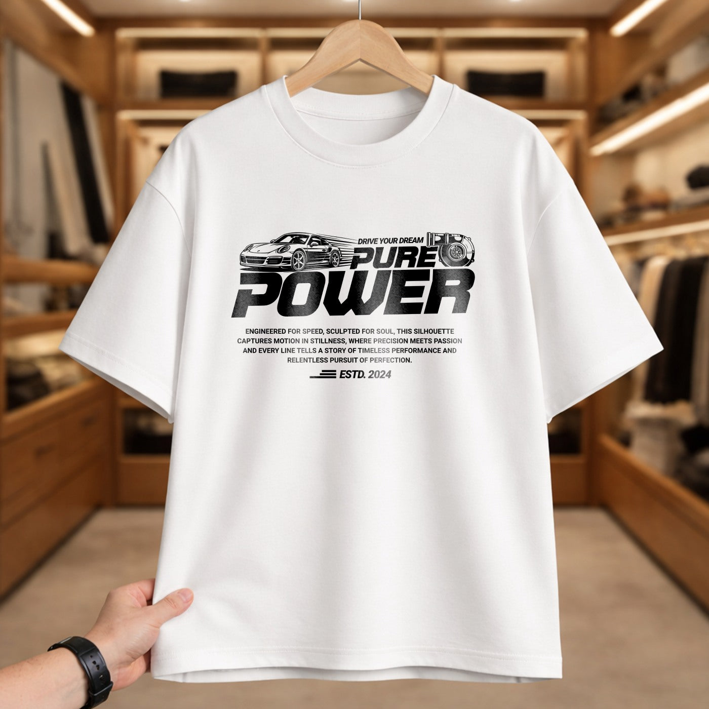 White t-shirt with 'PURE POWER' text and car graphics on a hanger in a clothing store.