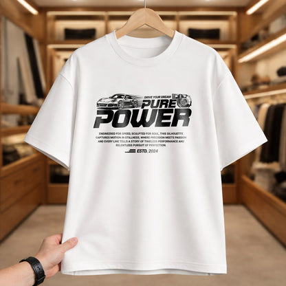 White t-shirt with 'PURE POWER' text and car graphics on a hanger in a clothing store.
