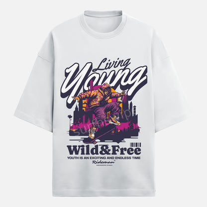 White t-shirt with graphic design featuring a person on a skateboard and text 'Living Young Wild & Free' on a white background.
