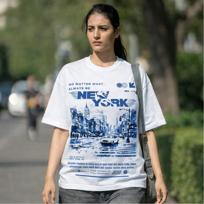 Woman wearing a white t-shirt with New York cityscape design outdoors.
