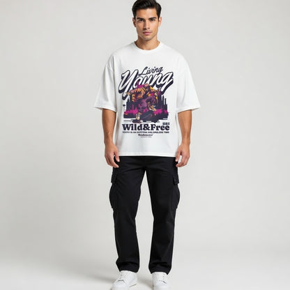 Man wearing a white t-shirt with colorful graphics and text on a plain background