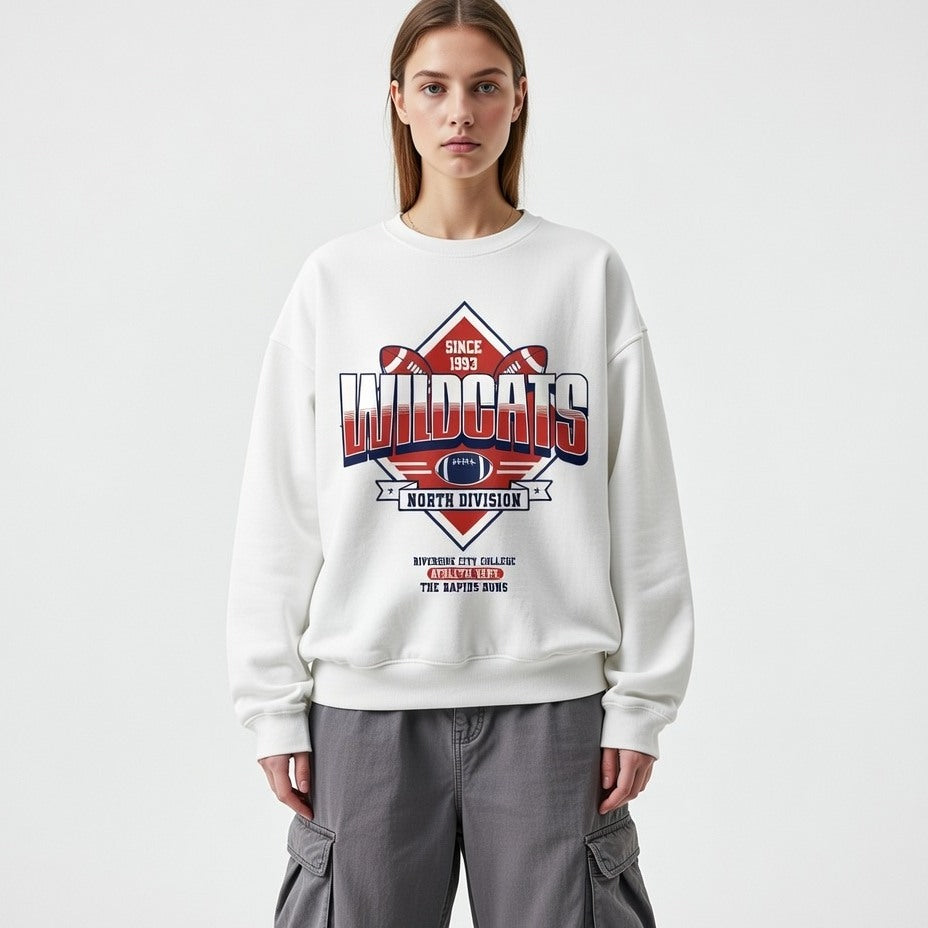 Person wearing a white sweatshirt with 'Wildcats' design on a plain background