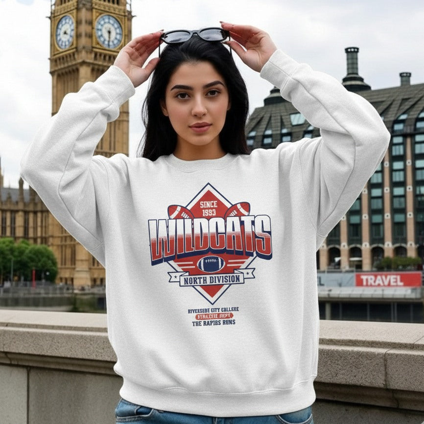 Person wearing a white sweatshirt with a graphic design in an urban setting
