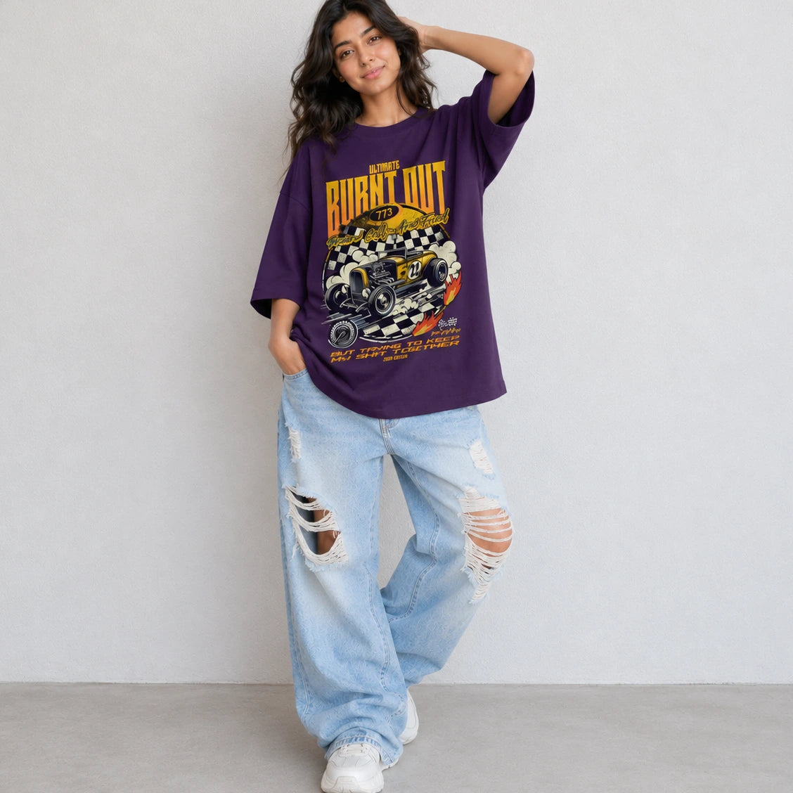 Woman wearing SURFNSWIPE Burnt Out Hot Rod oversized T-shirt in Purple styled with ripped wide-leg jeans